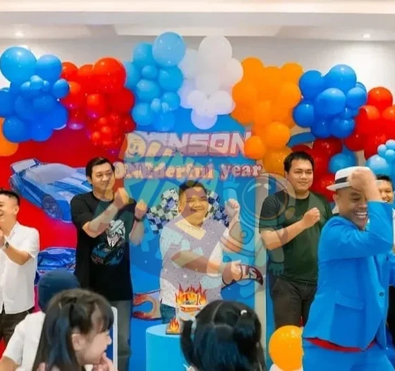 MC dan tamu bergembira di depan balloon arch pesta ulang tahun